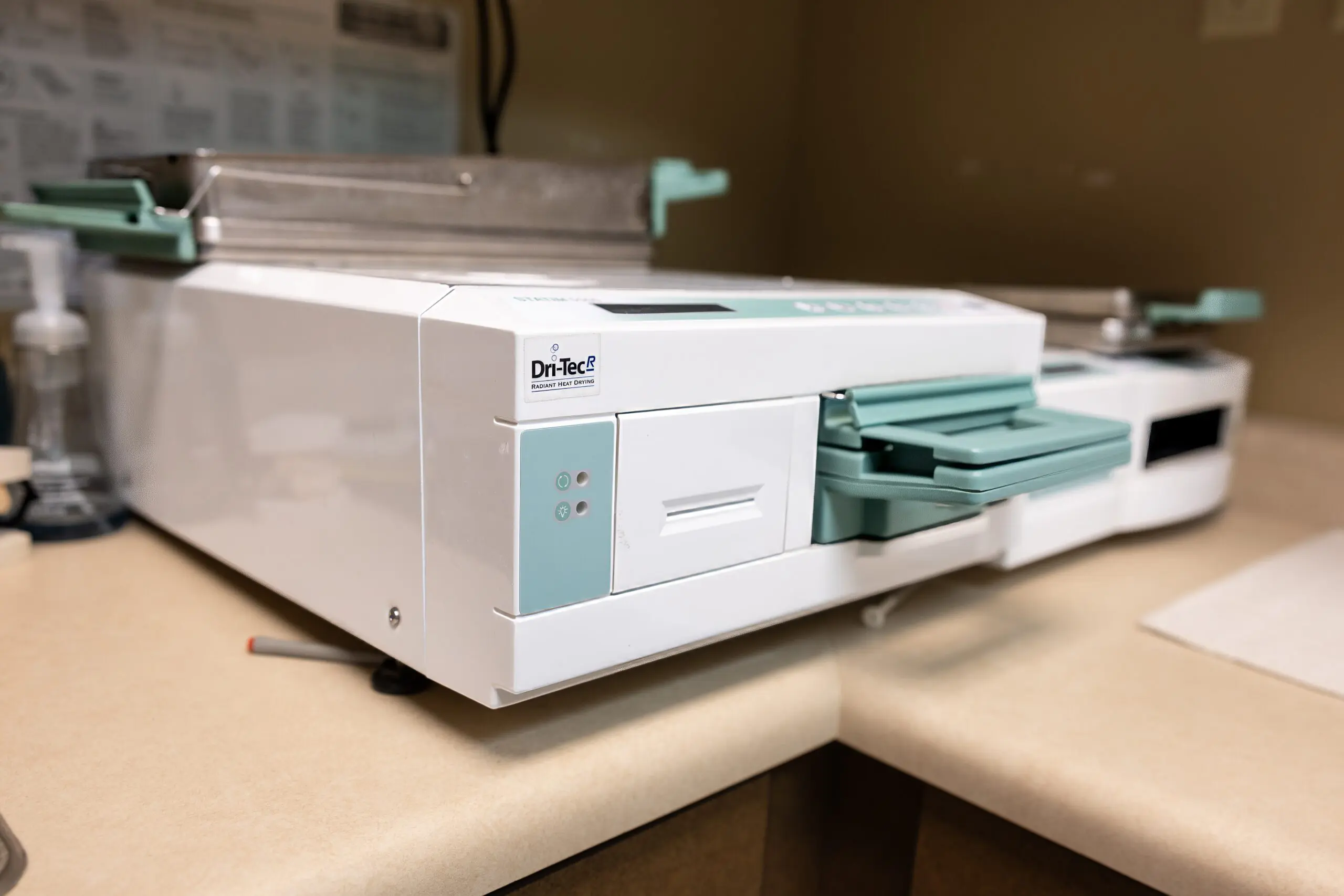 Dental sterilization or drying machine with trays on a countertop